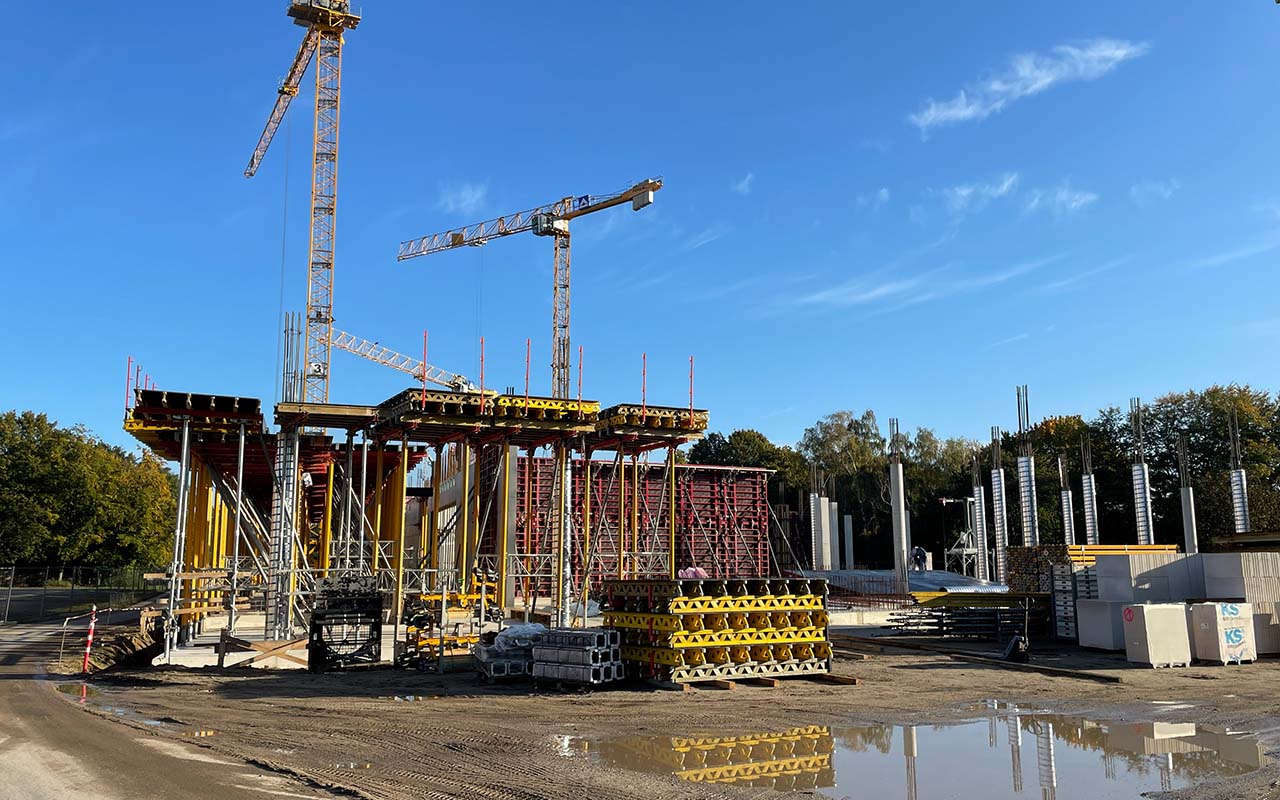 Baustelle des Schulcampus Süd im Oktober 2024 mit Kränen, Schalungselementen und errichteten Stahlbetonstützen. Die Aufnahme dokumentiert den Fortschritt des Schulbaus während der Rohbauphase, in der die Deckenschalung über dem Erdgeschoss hergestellt wurde.